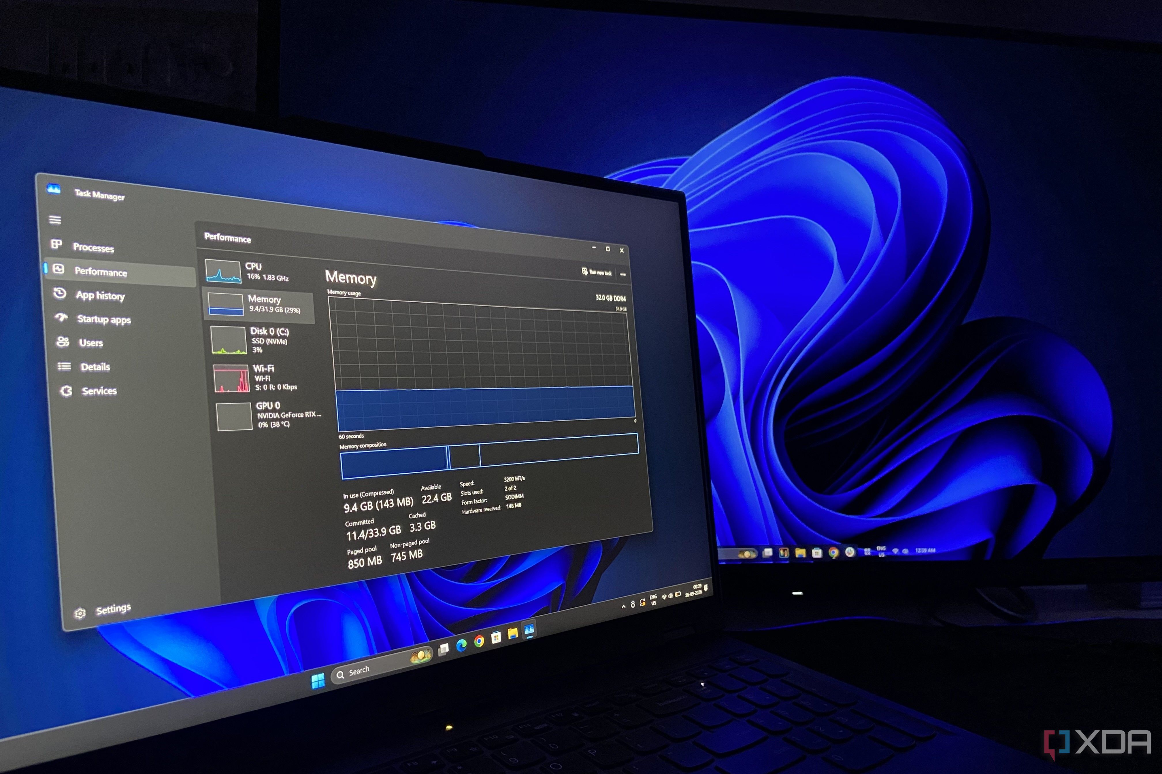 A laptop running task manager next to a desktop PC.