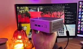 Immich in background with mini pc being held up in front of it