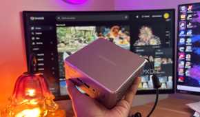 Immich in background with mini pc being held up in front of it