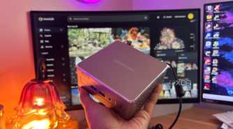 Immich in background with mini pc being held up in front of it