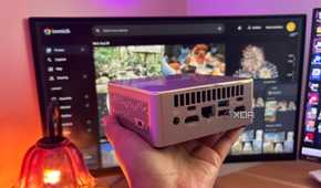Immich in background with mini pc being held up in front of it