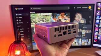 Immich in background with mini pc being held up in front of it