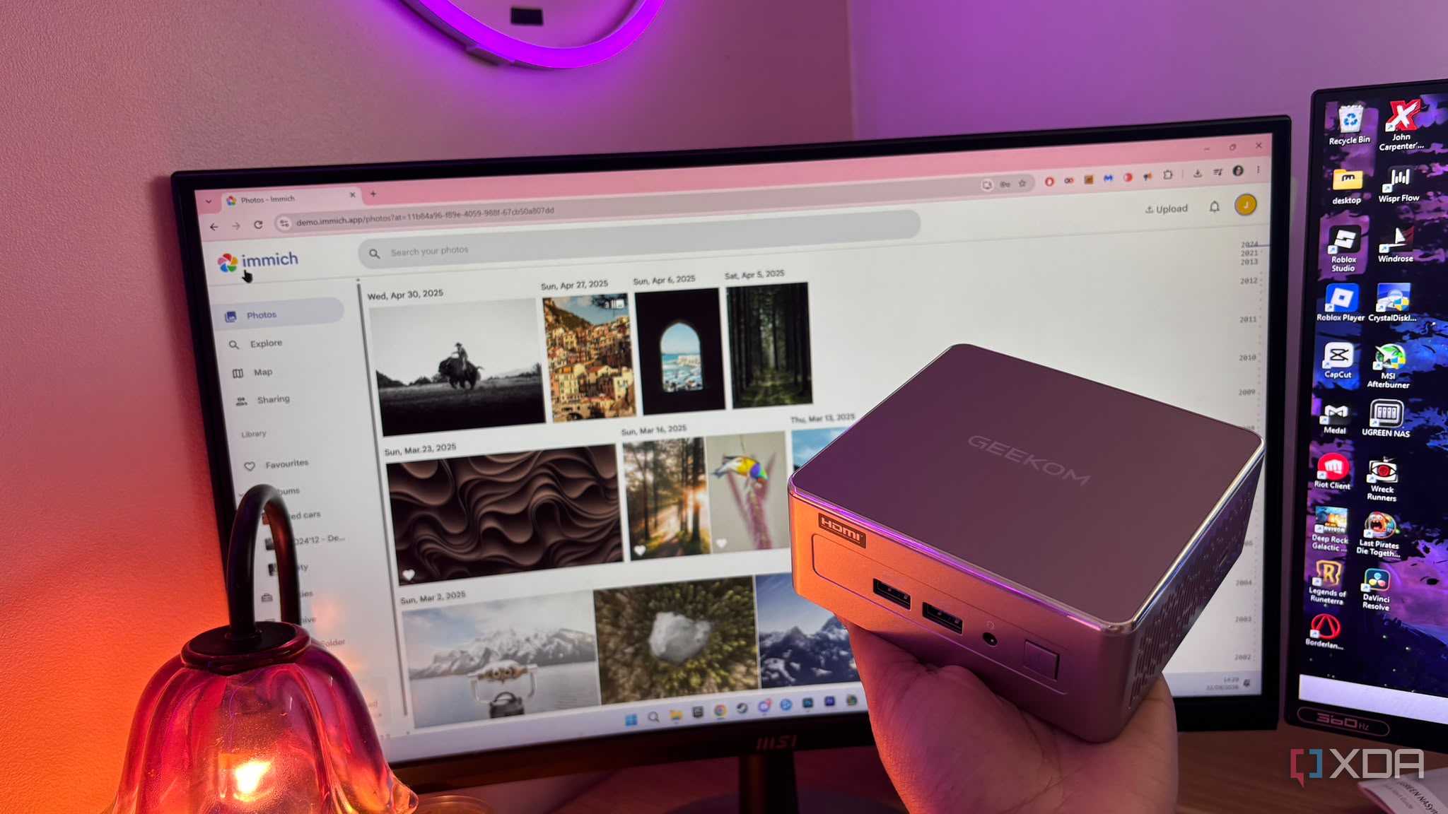 Immich in background with mini pc being held up in front of it