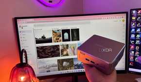 Immich in background with mini pc being held up in front of it