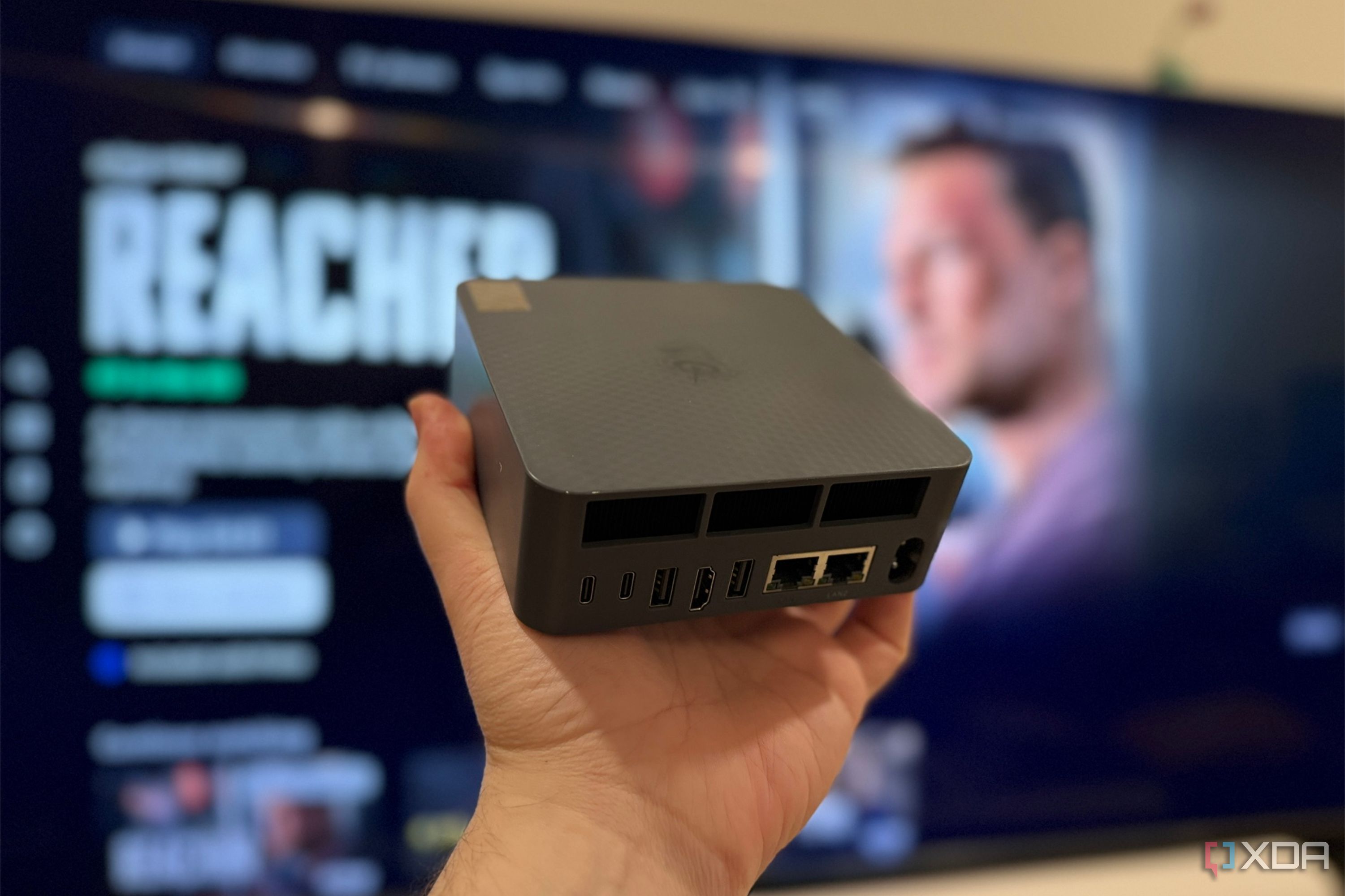 mini pc held in front of amazon fire movie