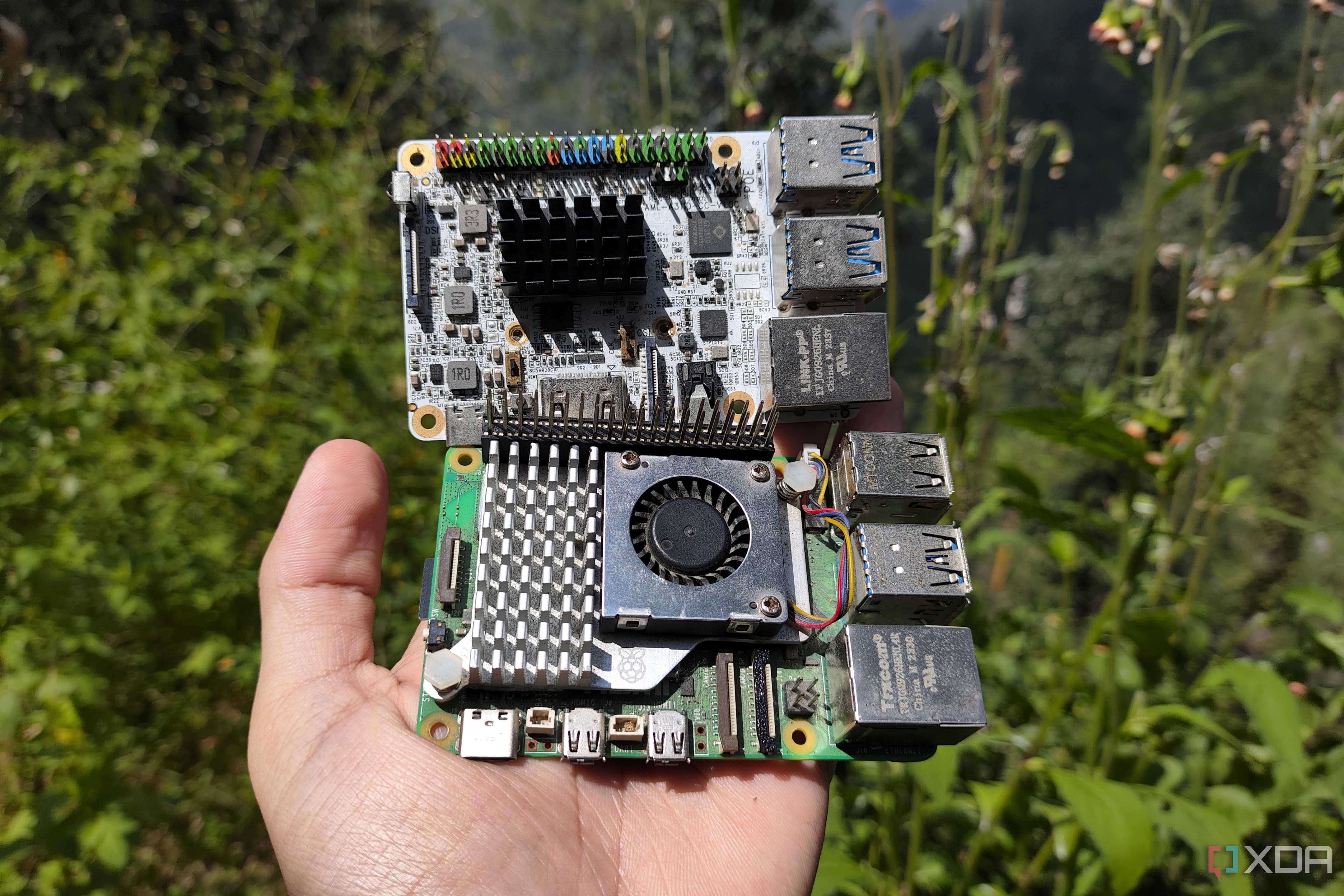 A person holding a Raspberry Pi 5 and a Libre Computer Alta