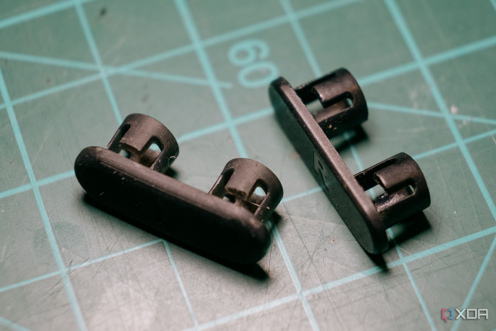 3D printed and original headphone clips on cutting mat