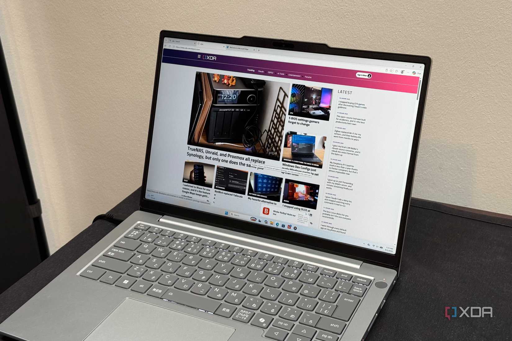 Silver Lenovo ThinkBook with a Japanese keyboard showing XDA in Edge