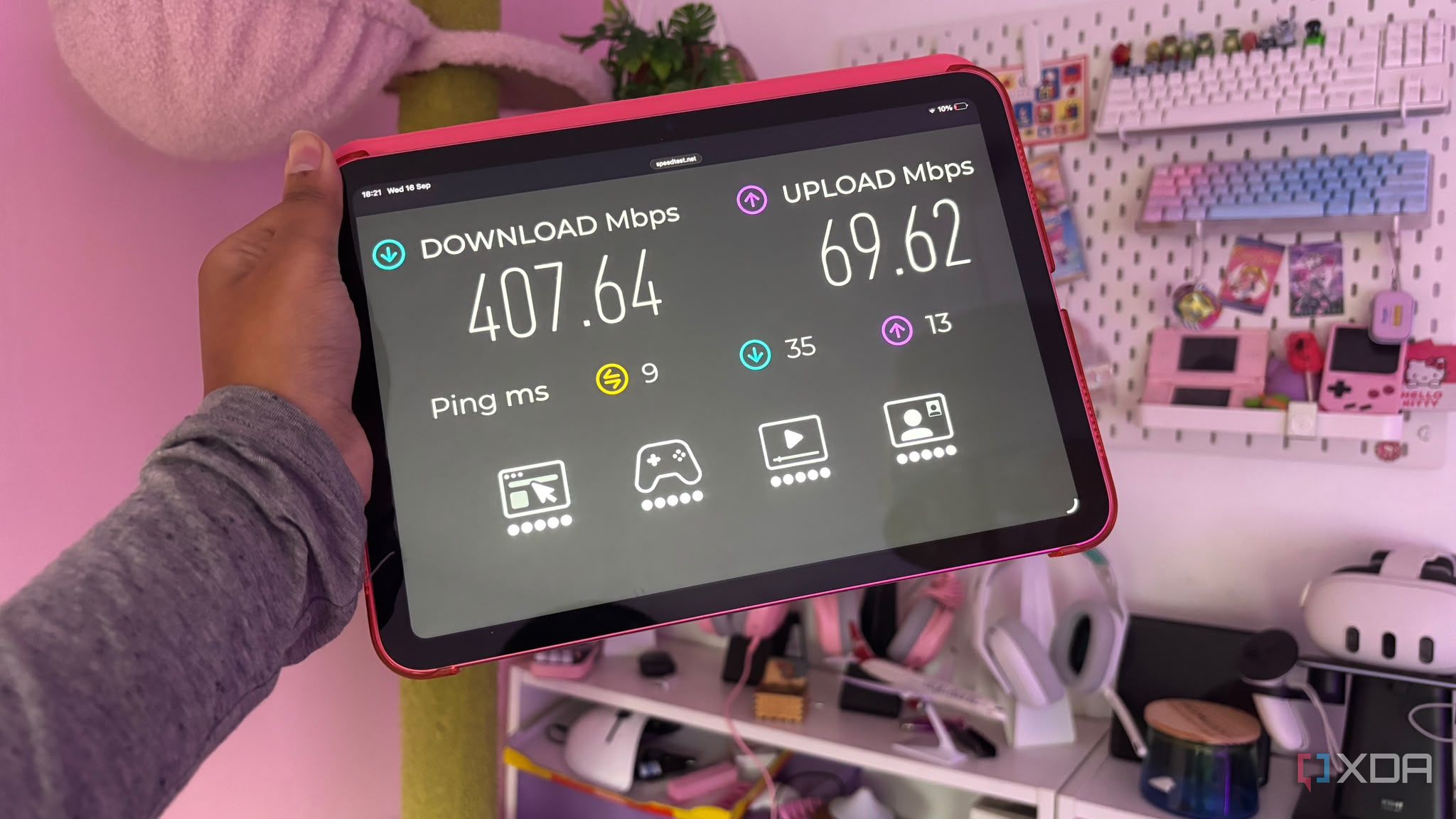 Internet speed test being shown on ipad screen held up against pink background