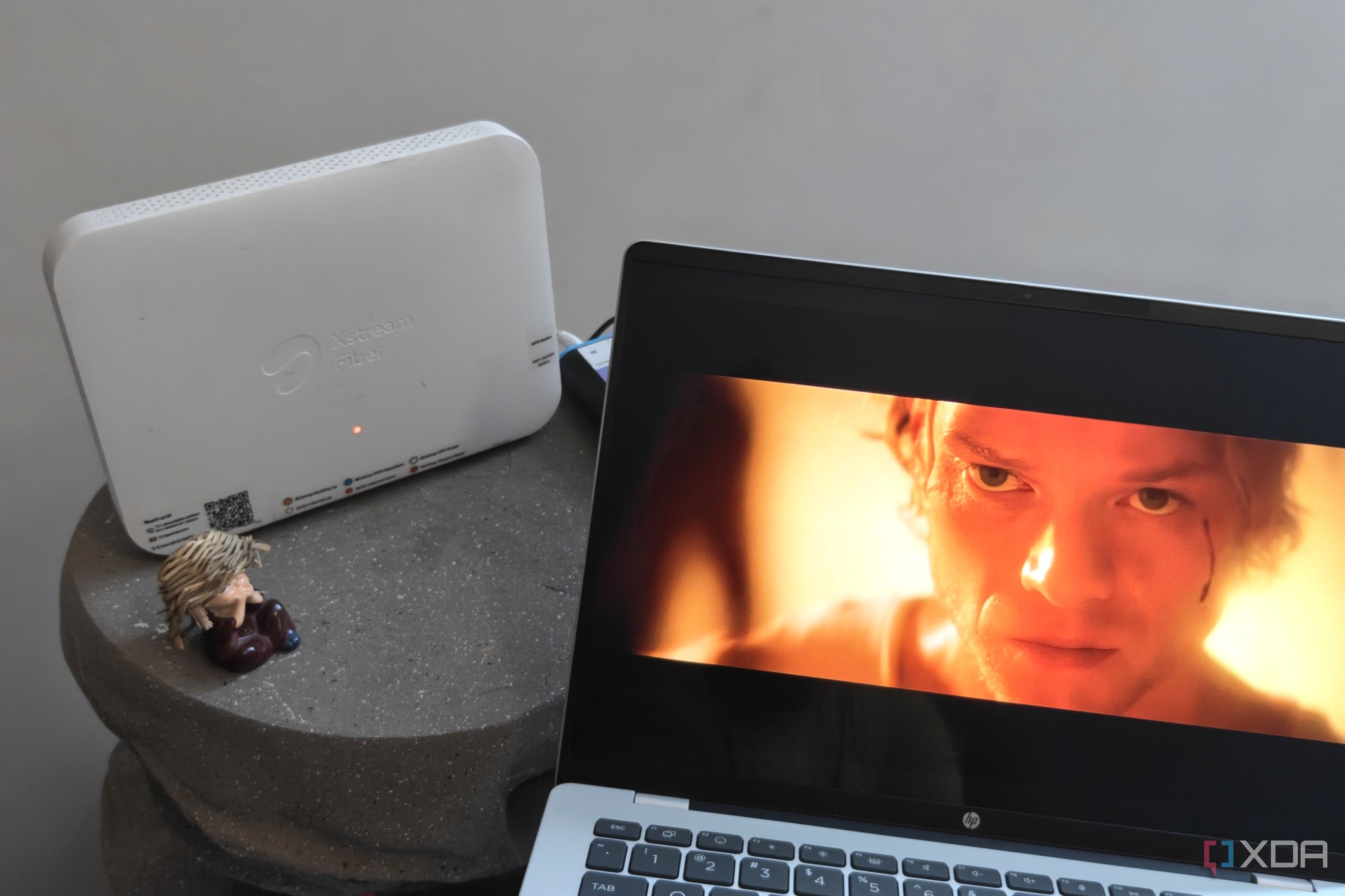 A laptop playing a video next to a Wi-Fi router