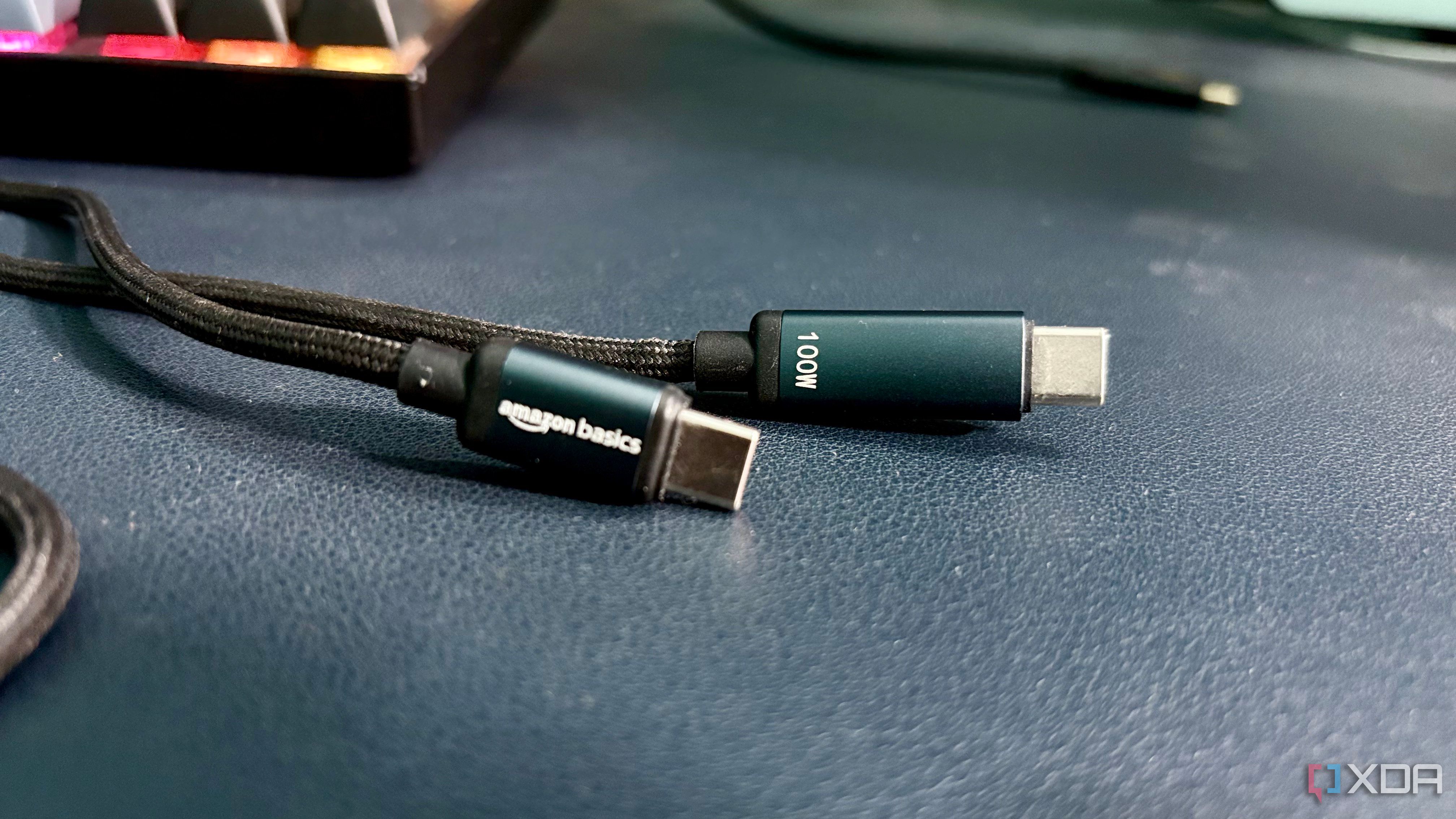 Both USB-C connectors of a braided Amazon Basics cable, one marked amazon basics and the other marked 100W