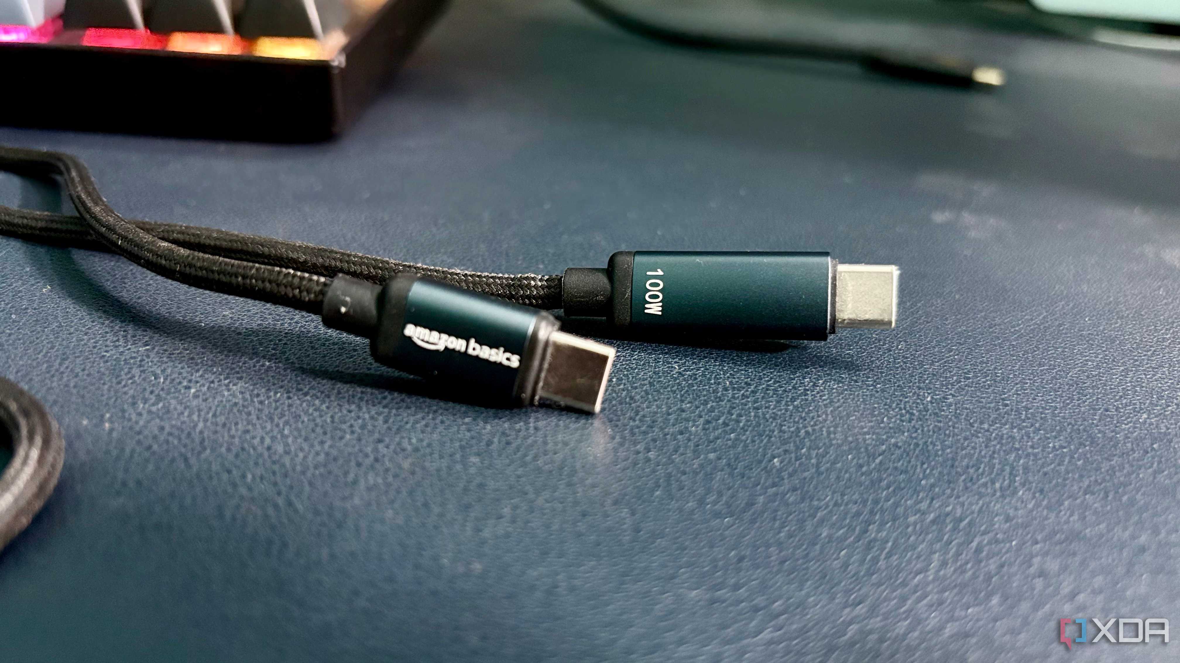 Both USB-C connectors of a braided Amazon Basics cable, one marked amazon basics and the other marked 100W