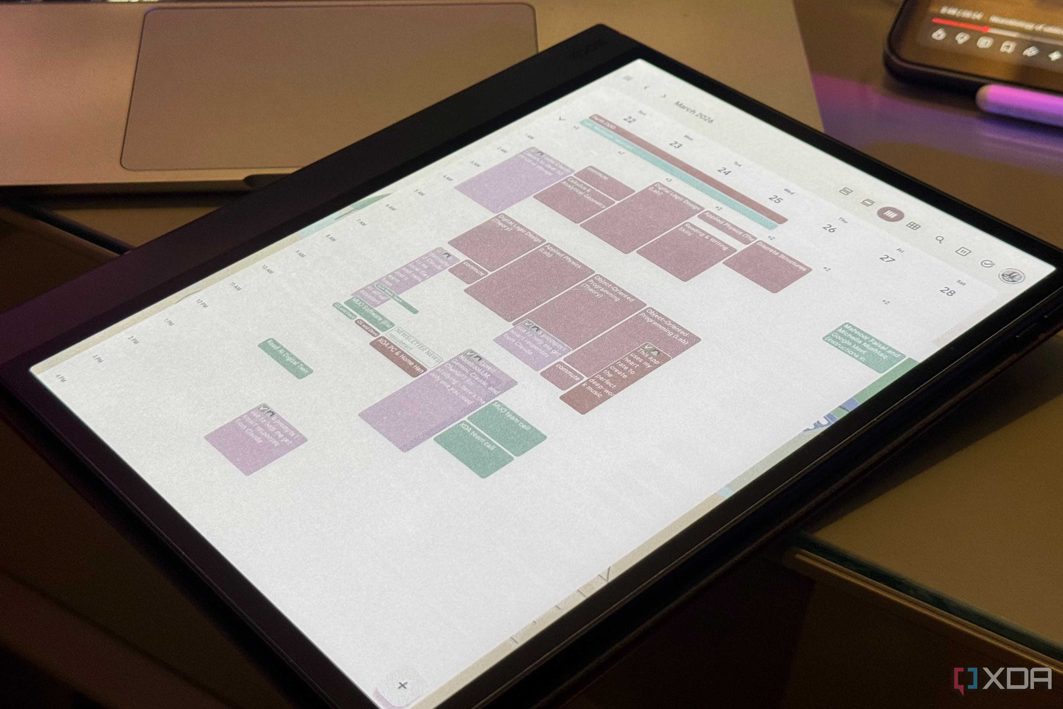 Boox color E Ink tablet showing a March week in Google Calendar beside a laptop and phone