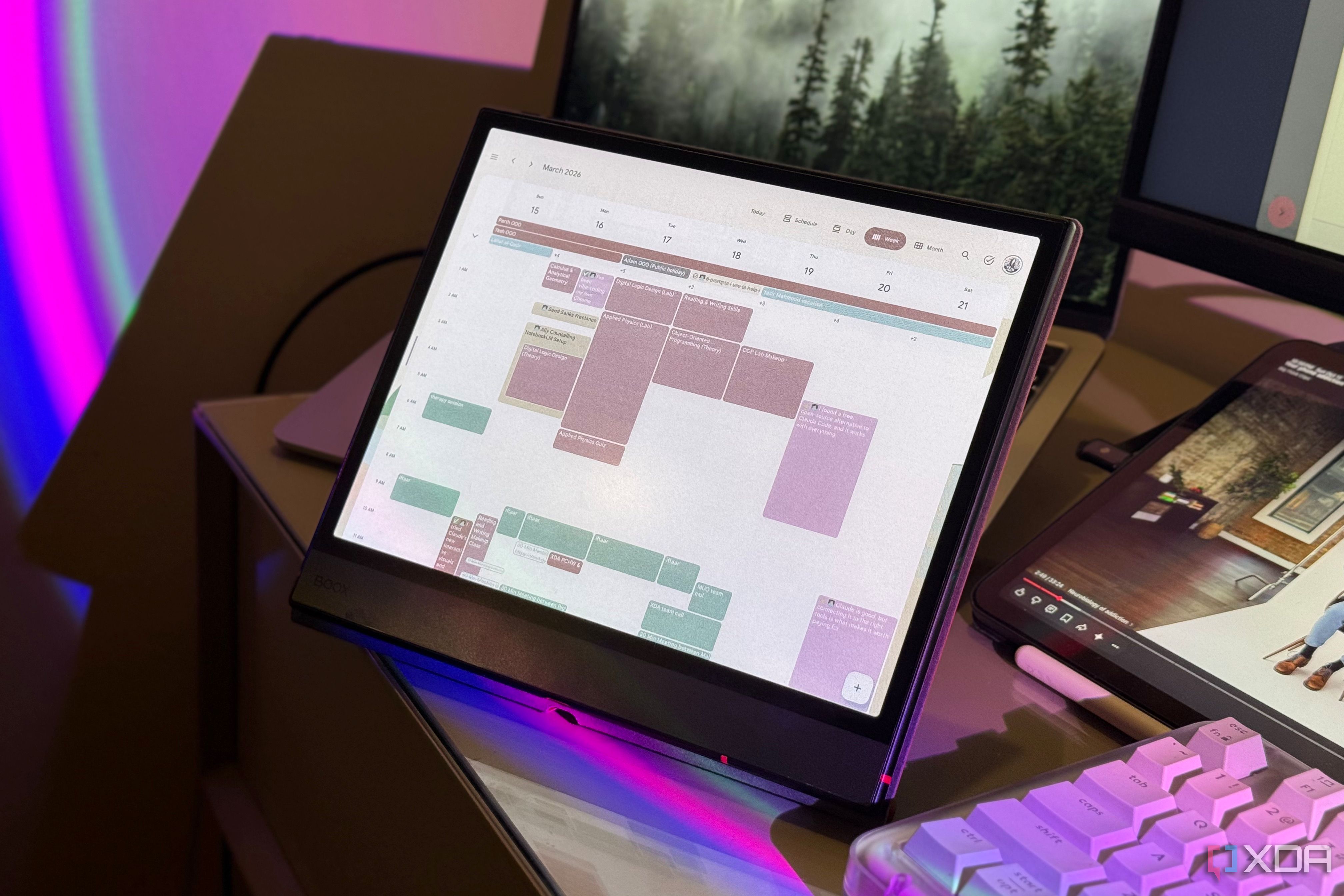 Boox tablet propped up on a desk showing Google Calendar under purple RGB lighting