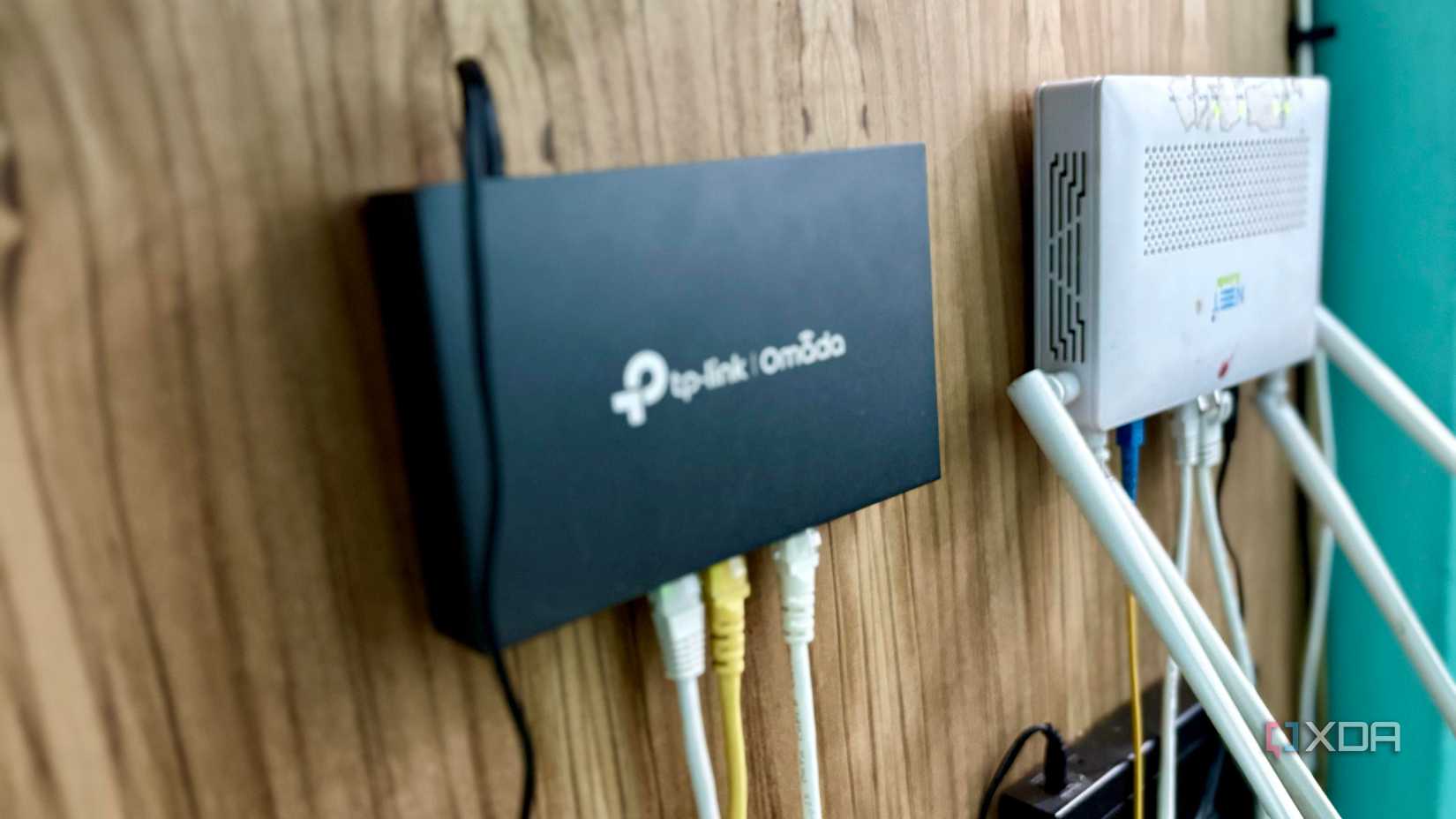 TP-Link ER605 gateway and the ISP’s ONT mounted side by side on a wooden wall
