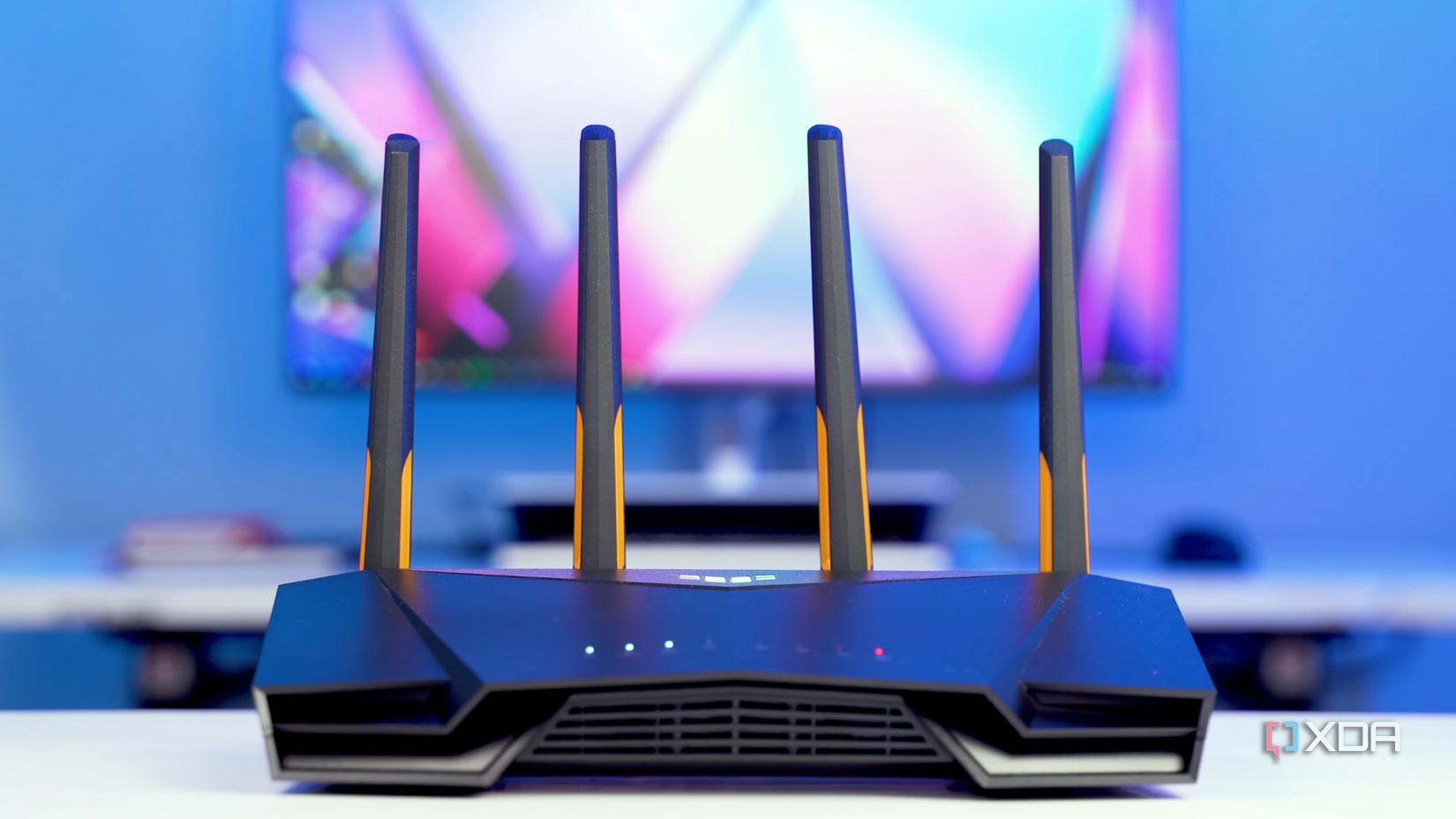 an asus gaming router is placed on the table with television behind