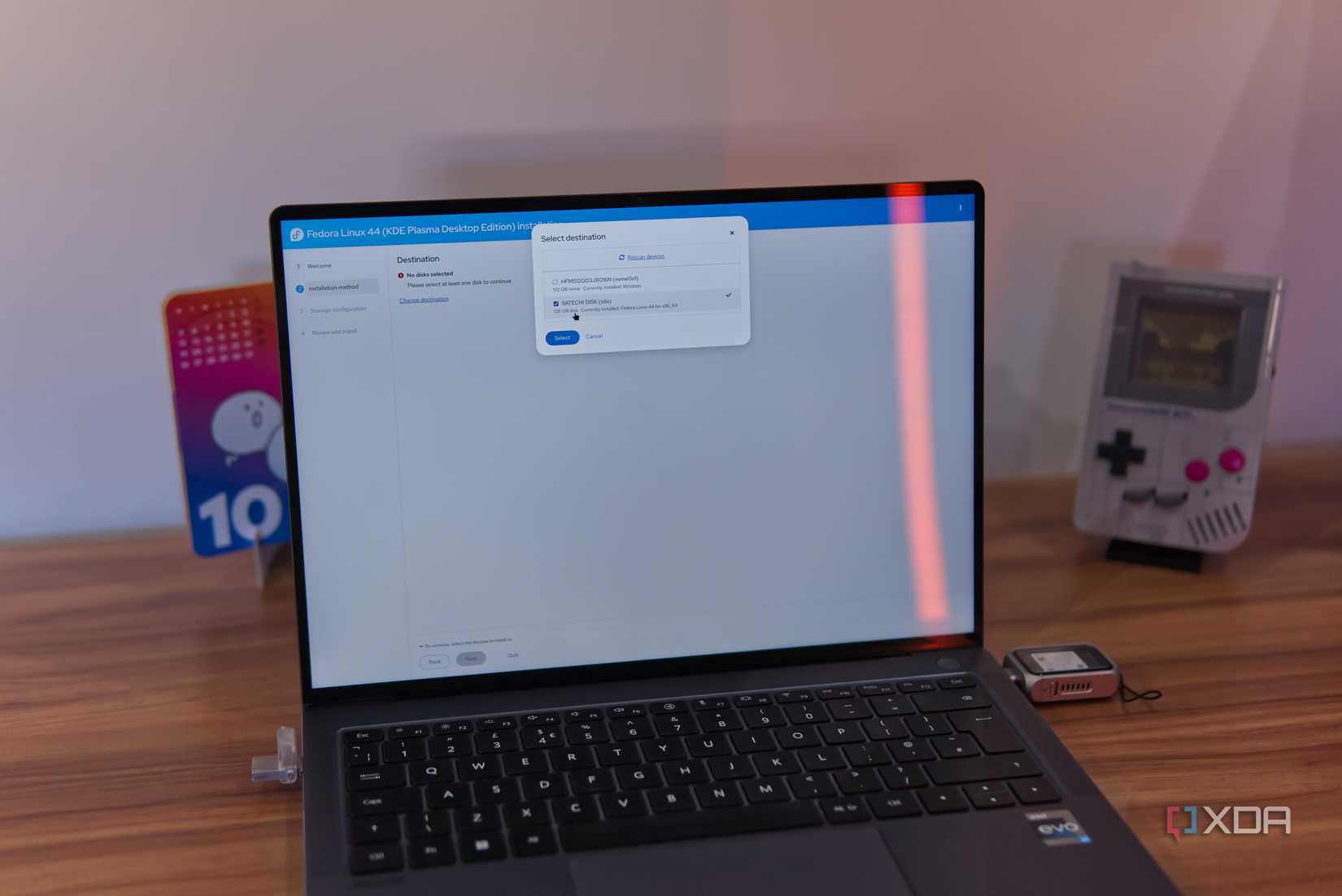 A laptop showing the Fedora installar offering the user the choice of what drive to install to. A USB drive is selected in the menu