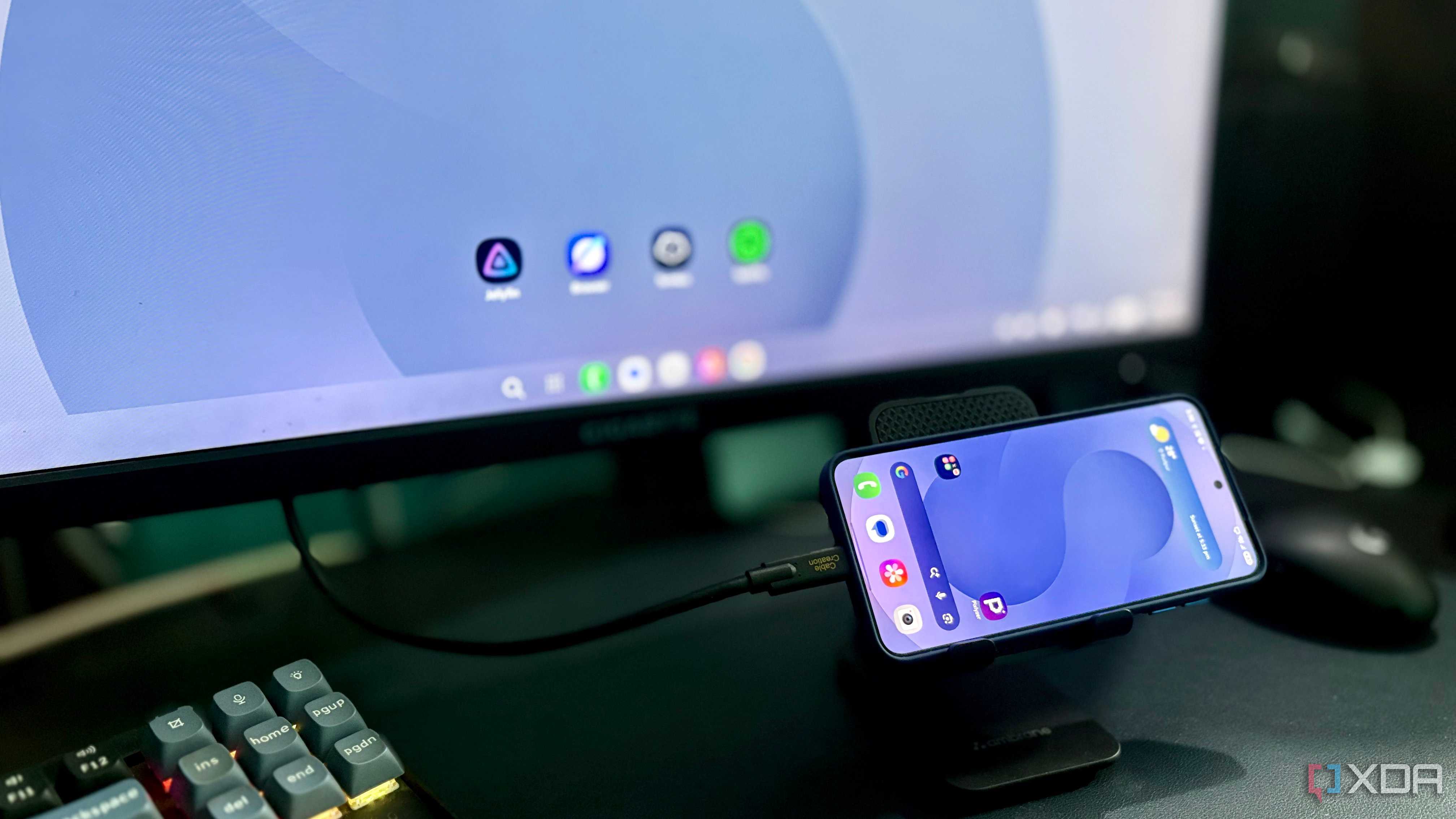 Samsung DeX desktop on a Gigabyte monitor with a Galaxy phone in a stand, connected by a CableCreation cable