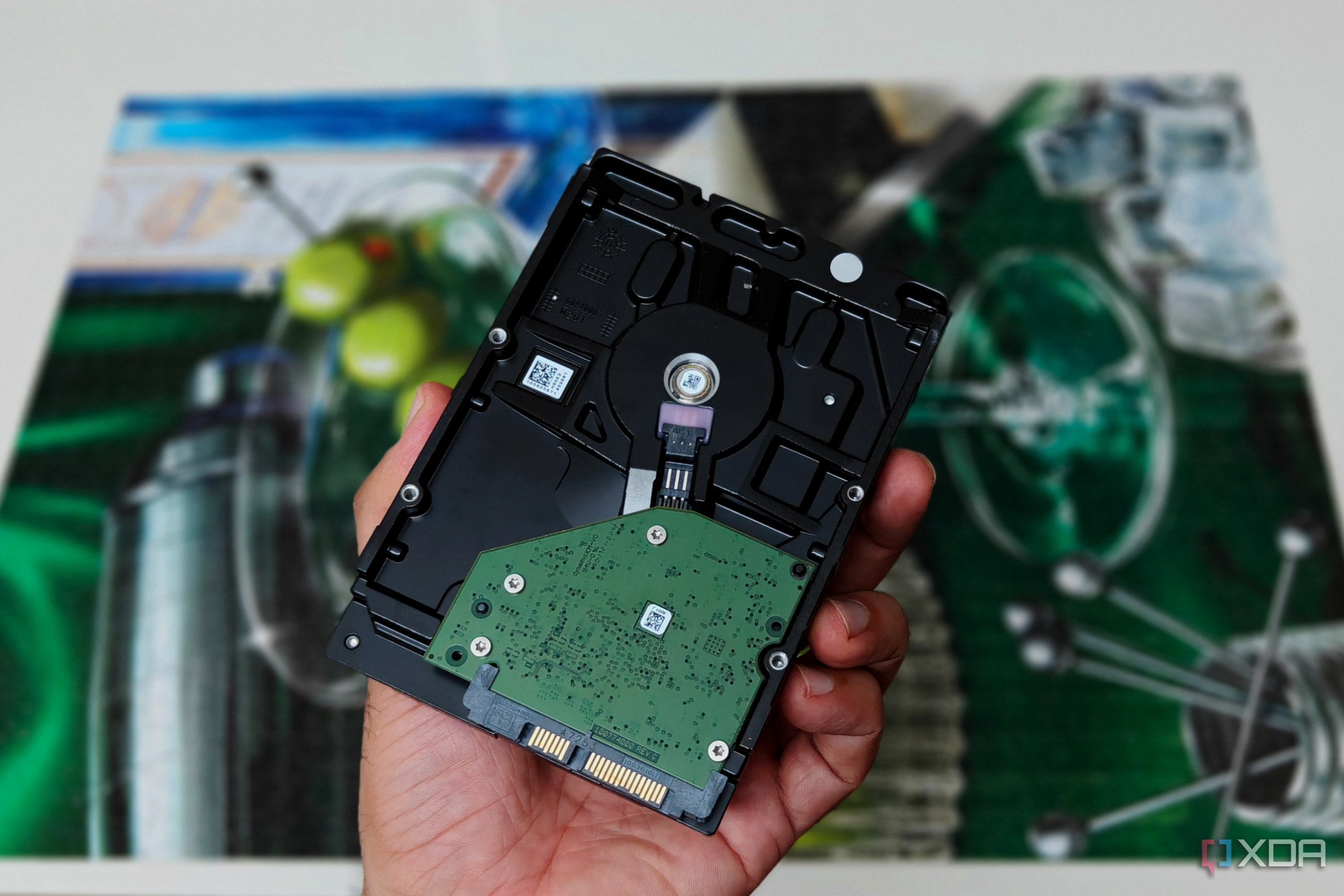 An internal hard drive held in a hand with a jigsaw puzzle in the background