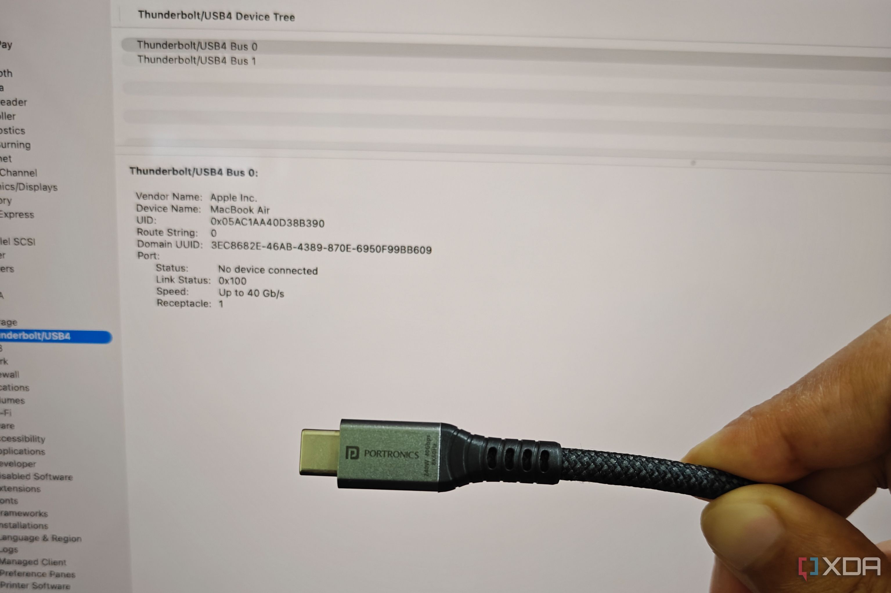usb 4 cable is shot in from of macbook air showing a system information tab