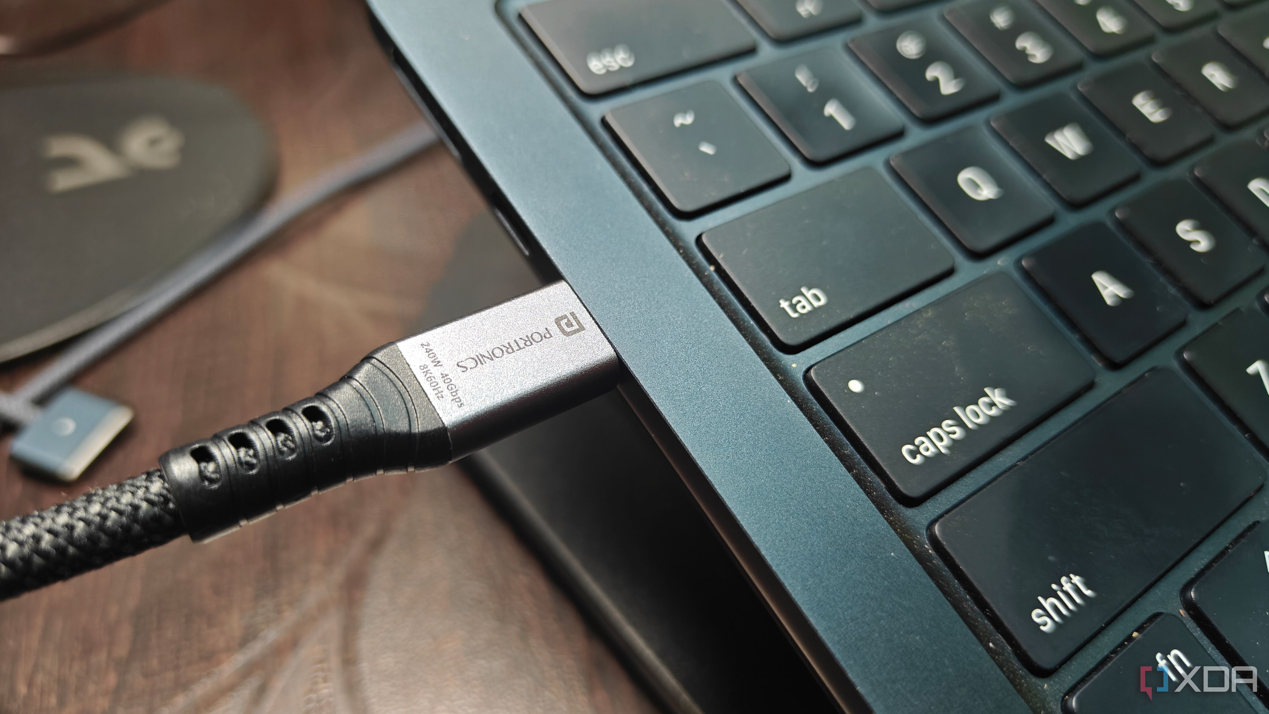 a portronics flash c2 plug marked 240w 40gbps 8k60hz plugged into a macbook air
