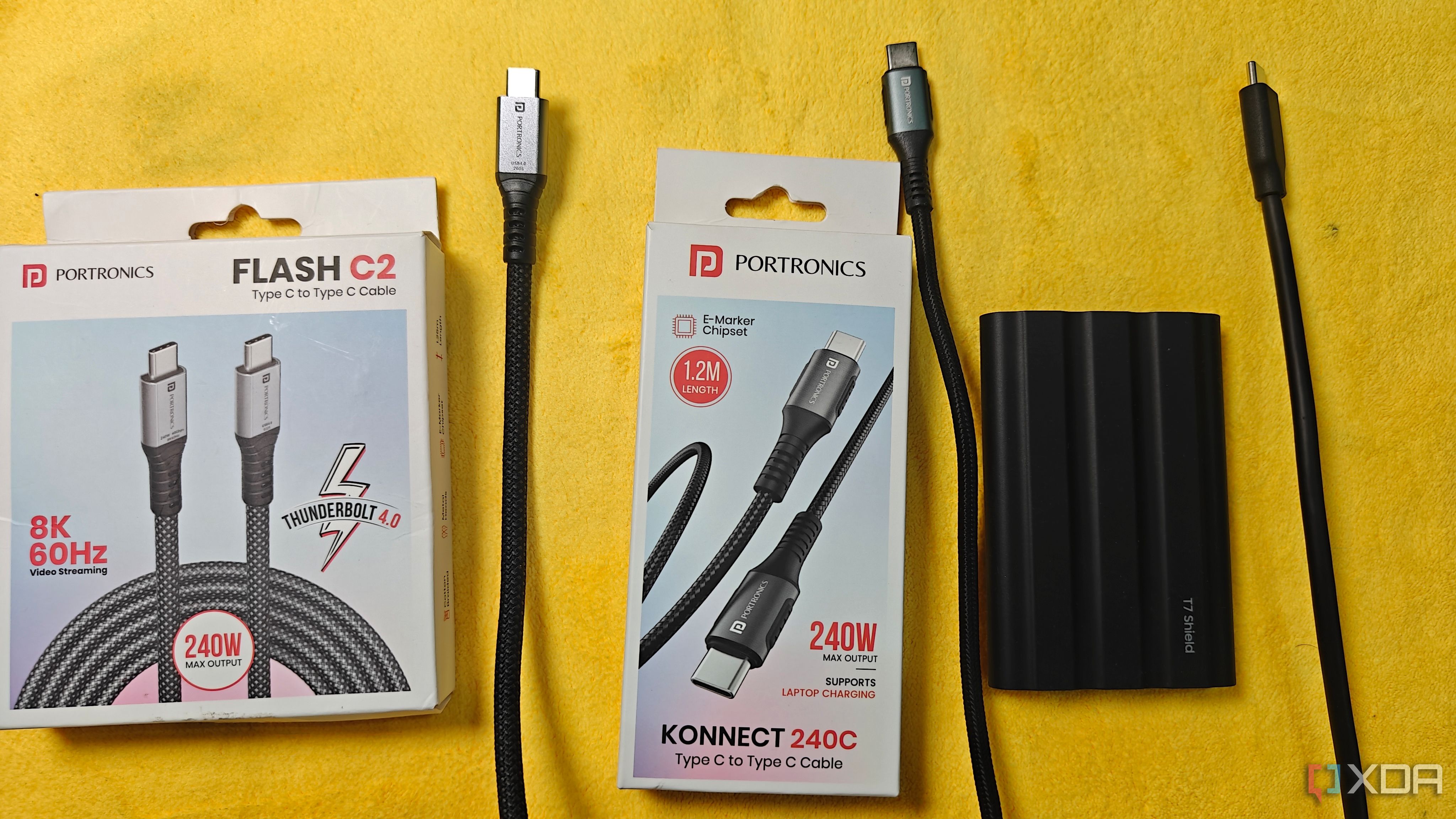 the portronics flash c2 and konnect 240c cables with their boxes beside a samsung t7 shield and its cable