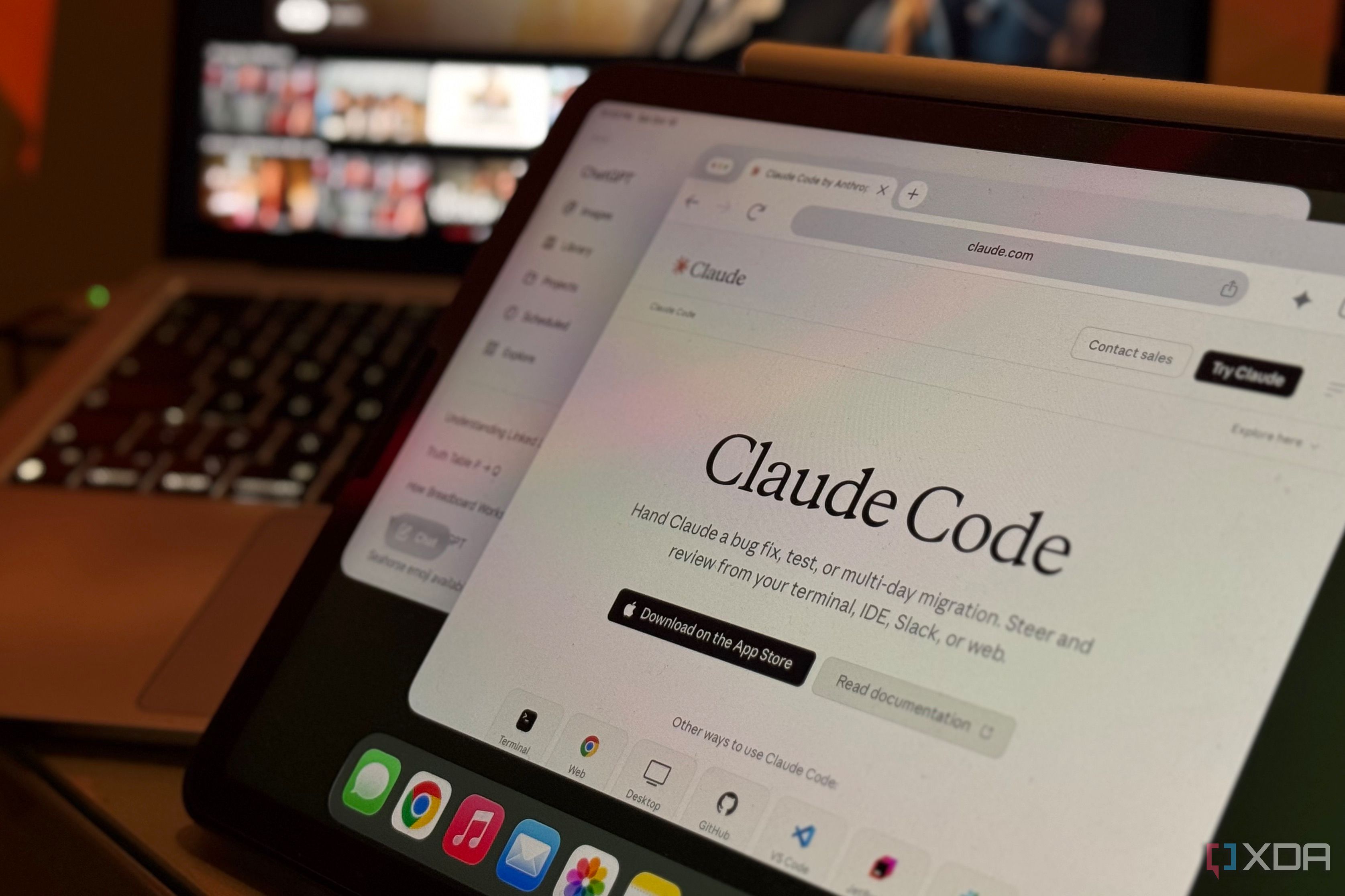 iPad showing the Claude Code page in Chrome, with a laptop and TV blurred behind it