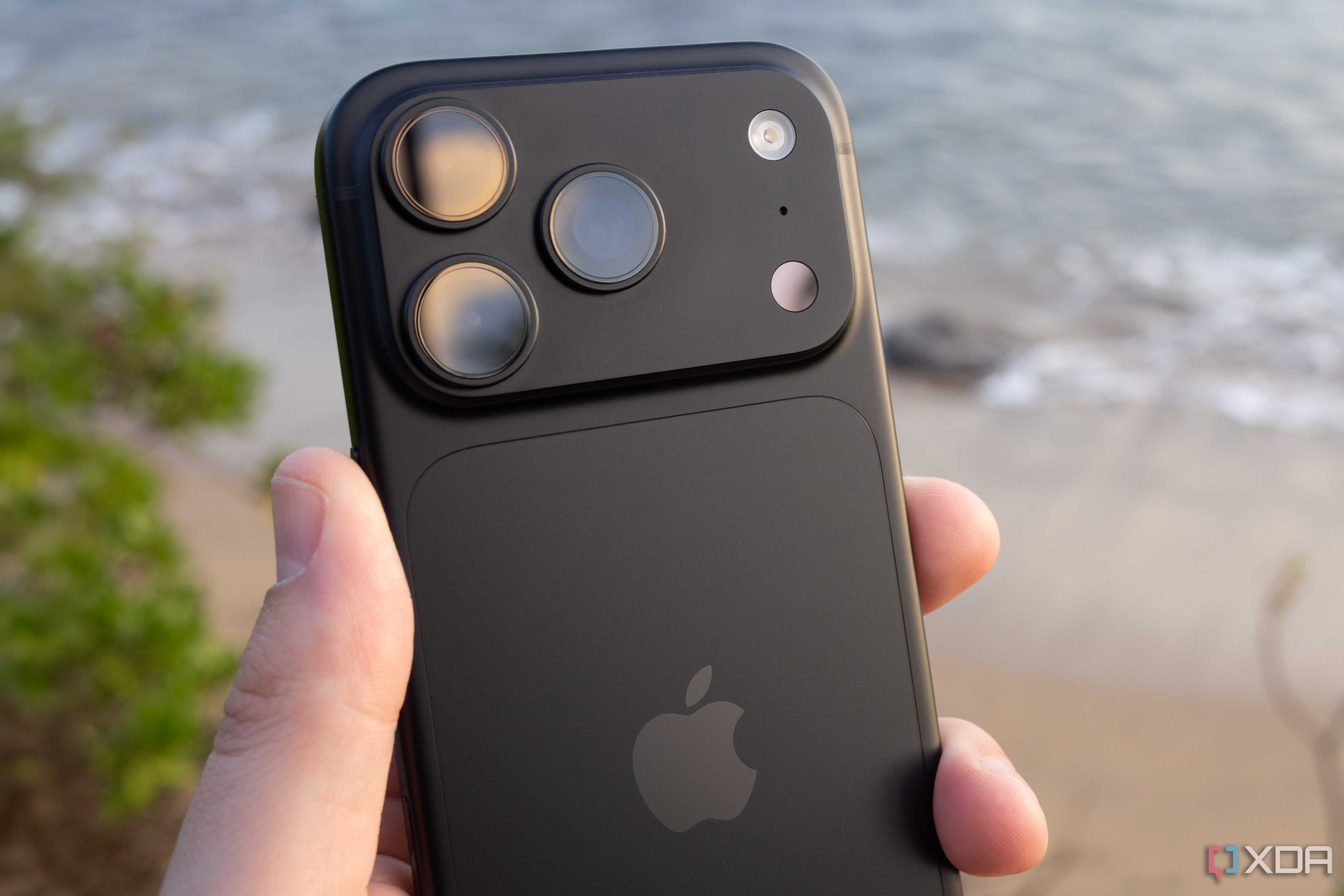 The iPhone 18 Pro being held in front of a beach