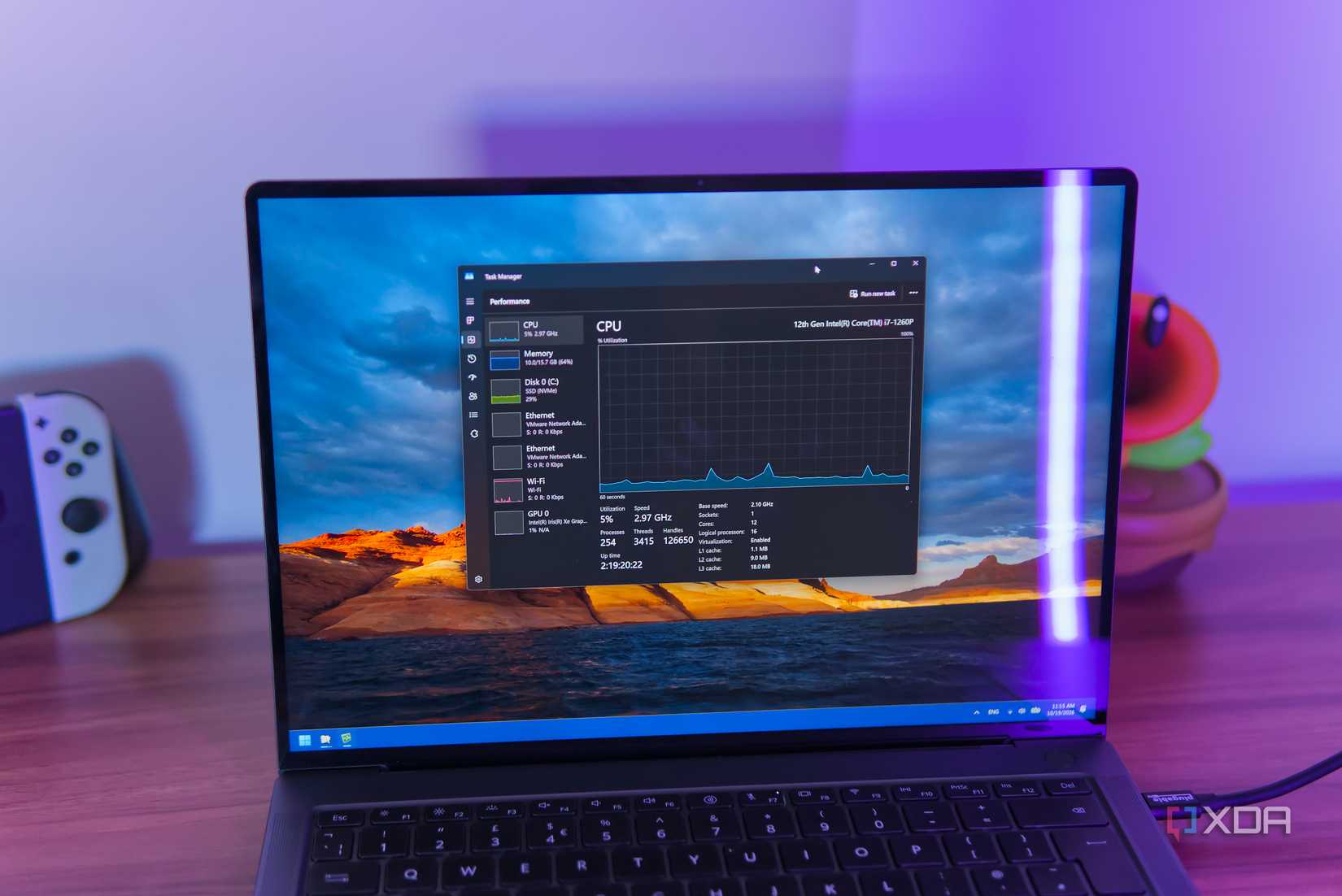 A Windows 11 laptop showing CPU usage in Task Manager while the entire drive is being compressed