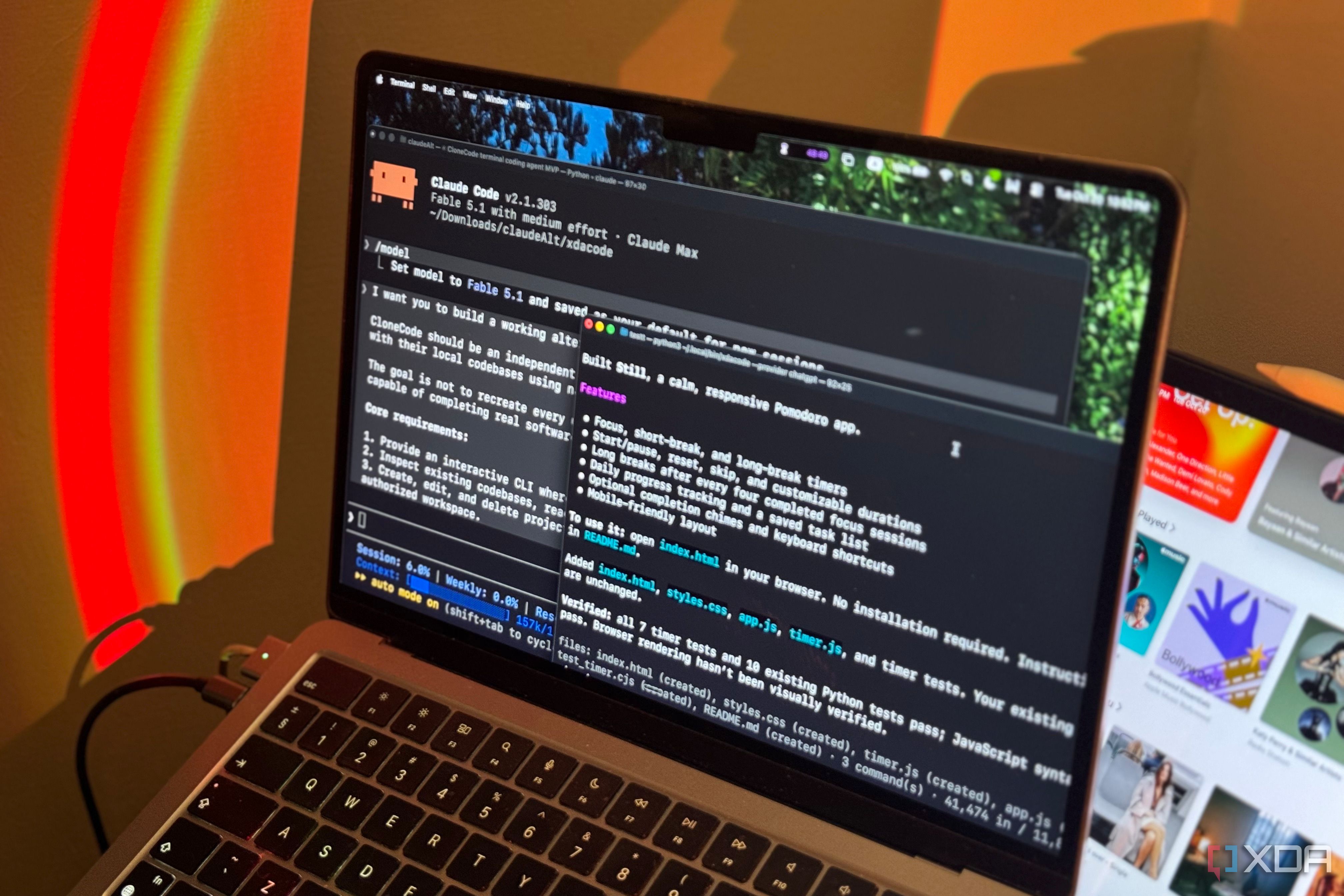 MacBook Air keyboard and screen with Claude Code terminals in warm orange lighting