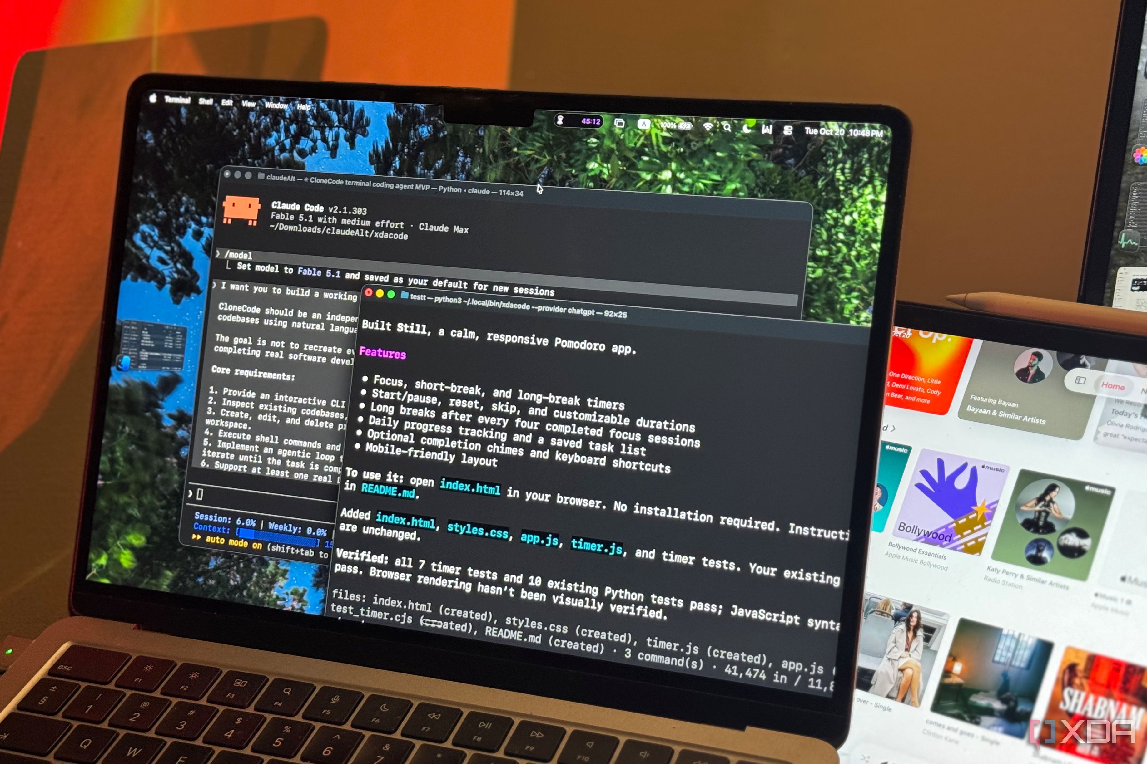 MacBook Air running Claude Code and XDACode terminals beside an iPad showing Apple Music
