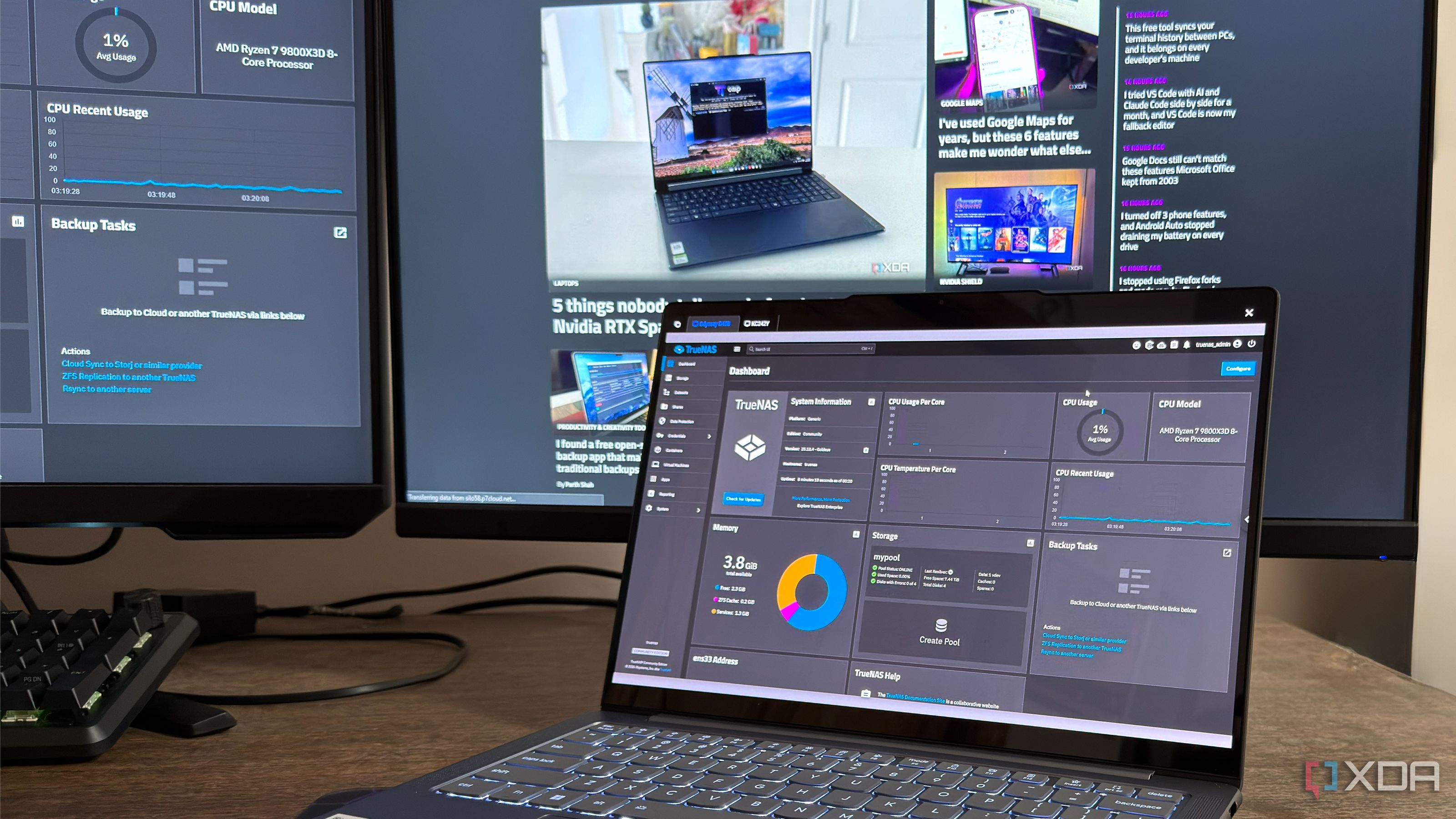 A laptop showing a TrueNAS dashboard with a monitor behind it