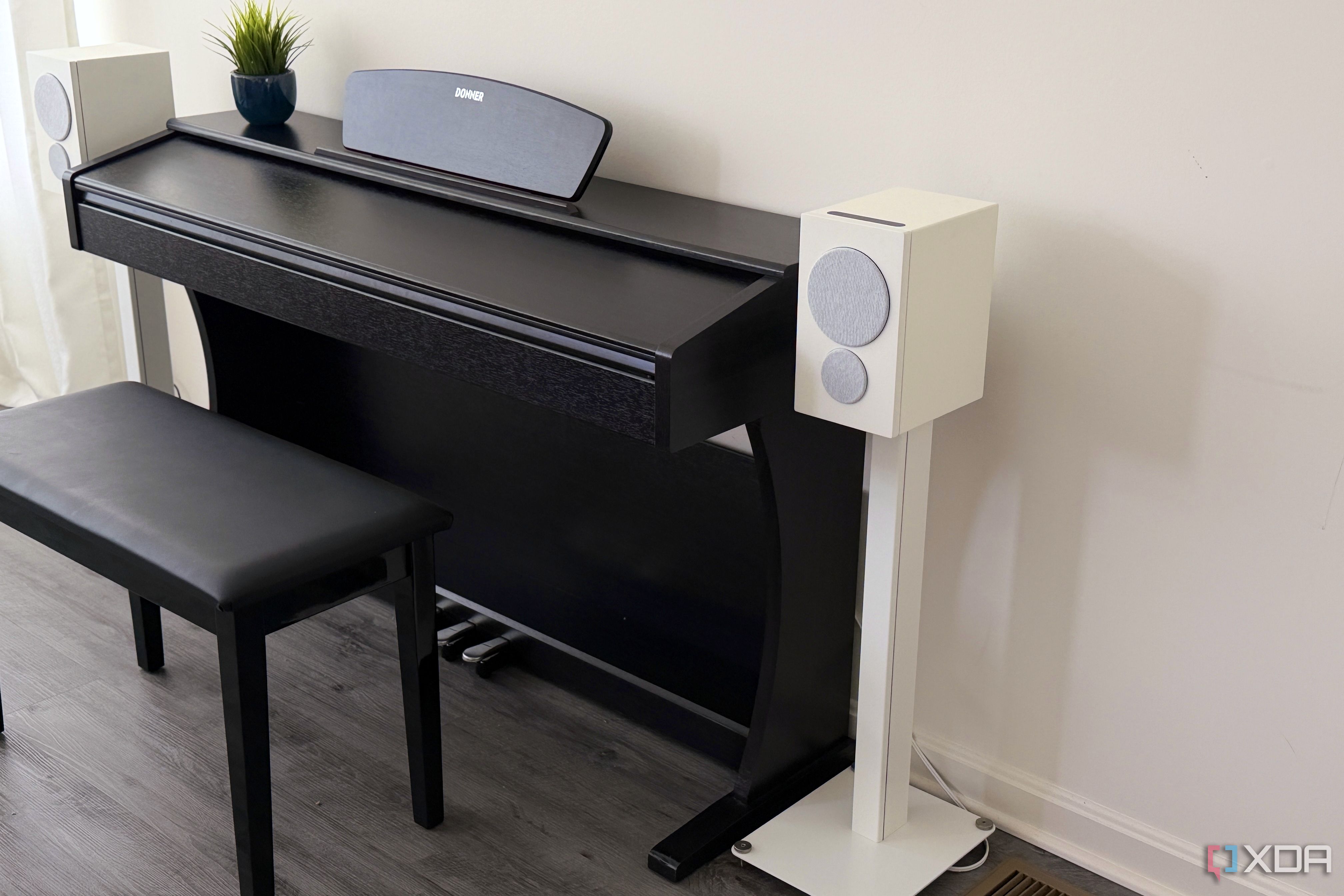 psb iq2 on a stand next to a piano