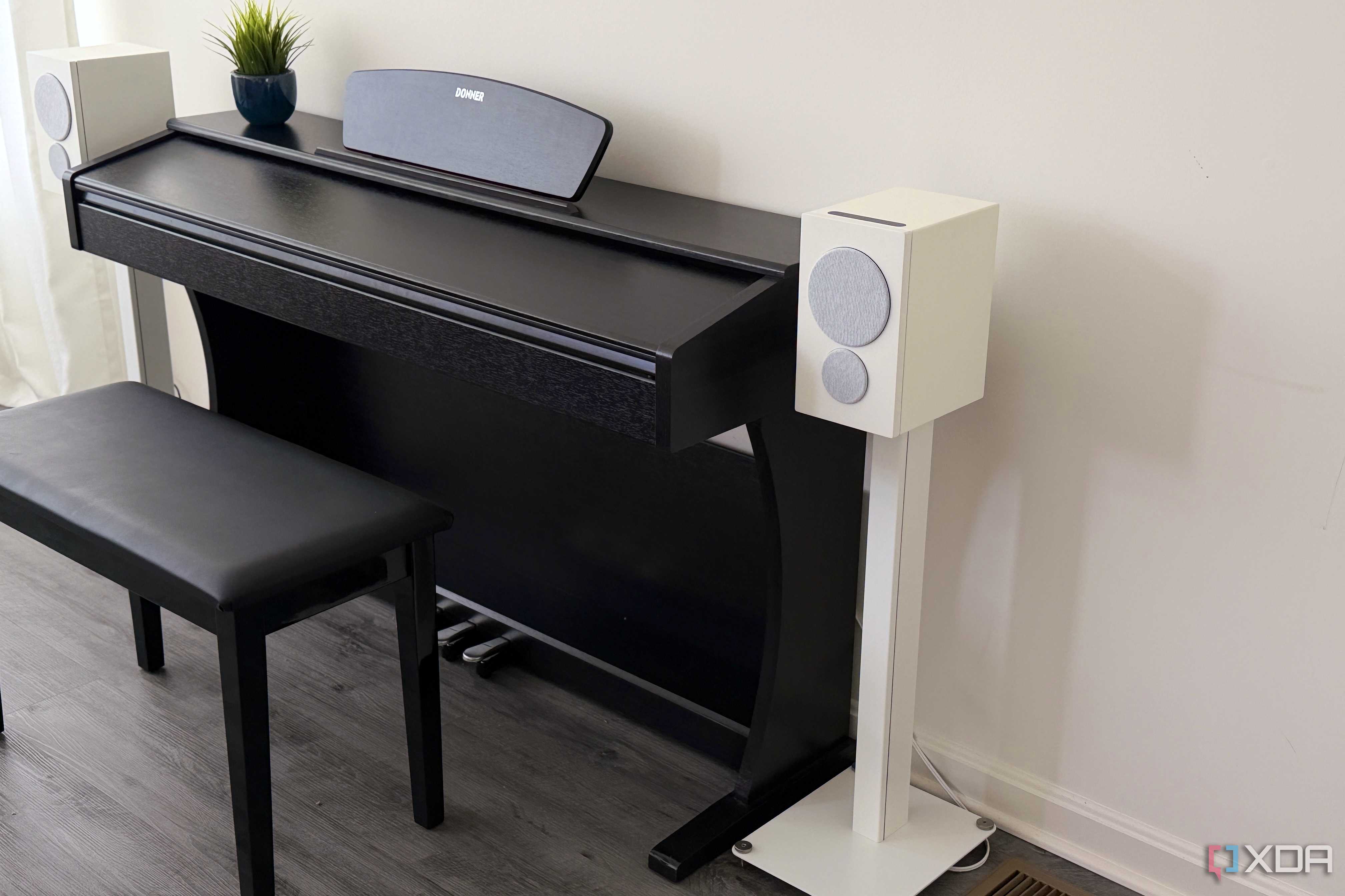 psb iq2 on a stand next to a piano