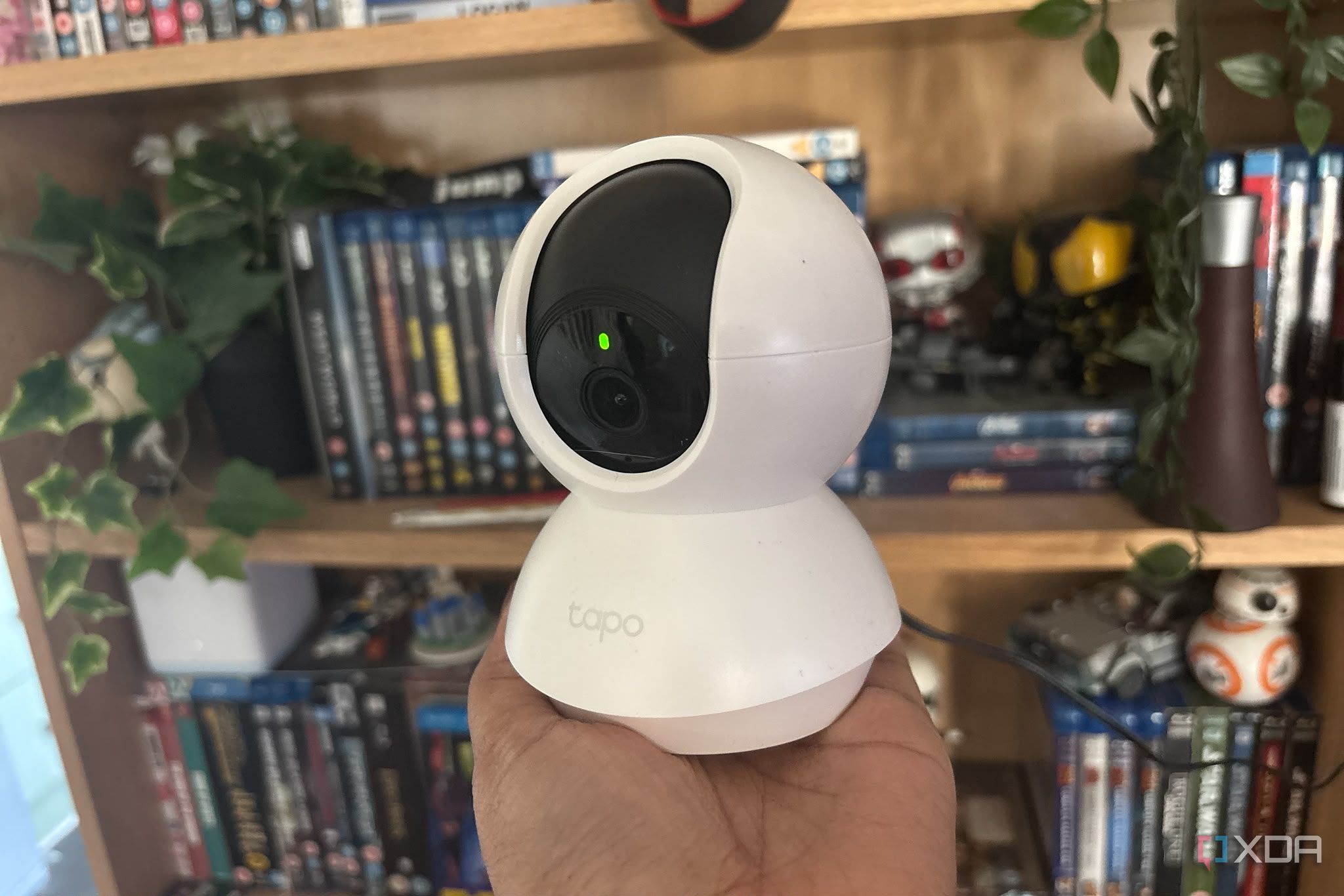 tapo camera being held up in front of shelf