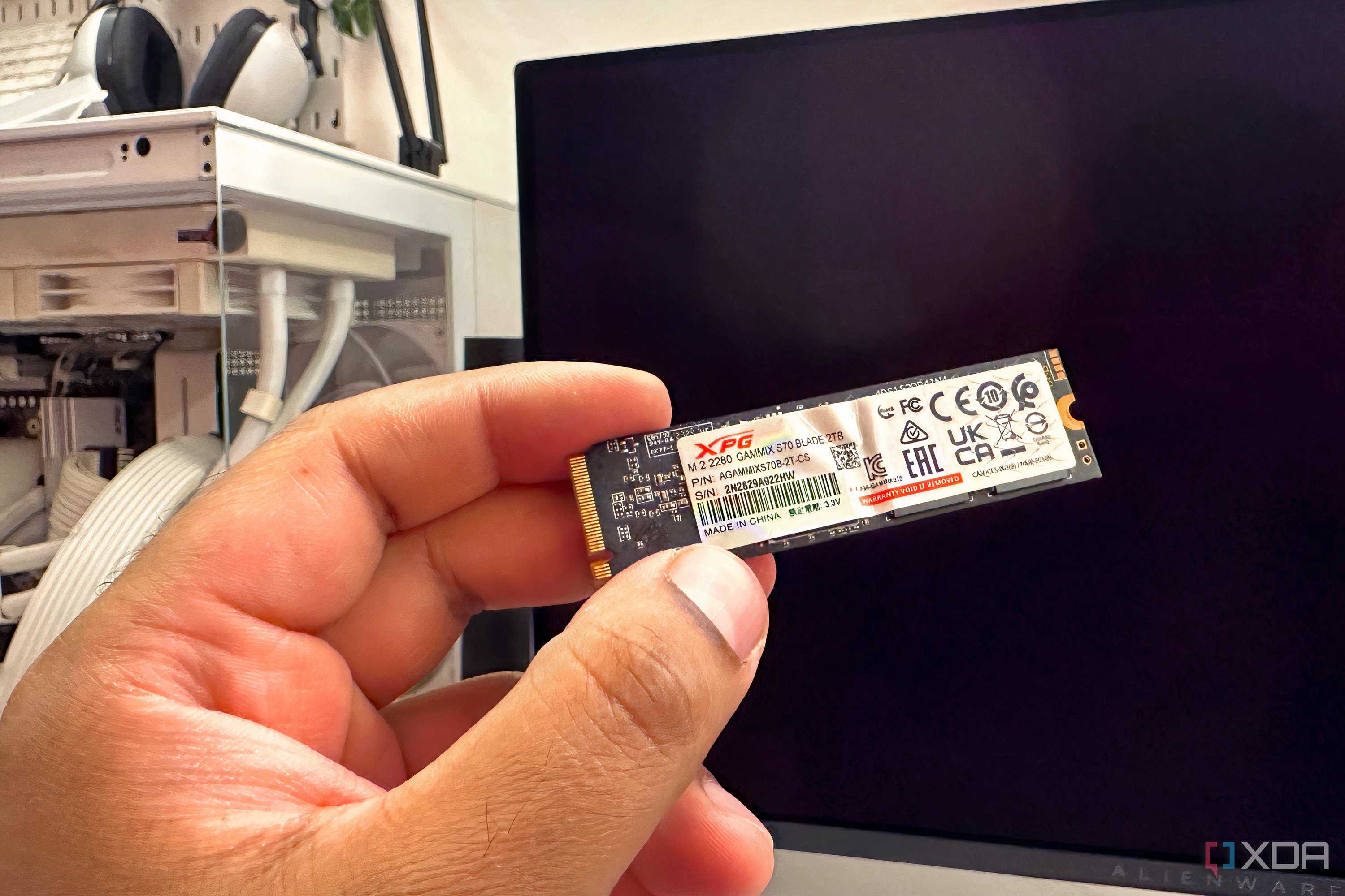 XPG Adata S70 Blade NVMe SSD held in front of a PC.